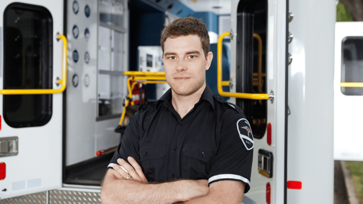 EMS worker standing in front of an open ambulance